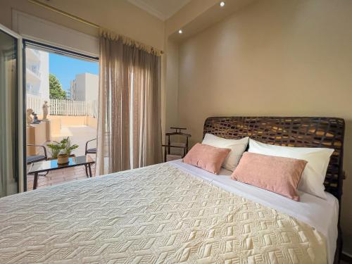 1 dormitorio con 1 cama grande con almohadas rosas en Athens Condonest Platon, en Atenas