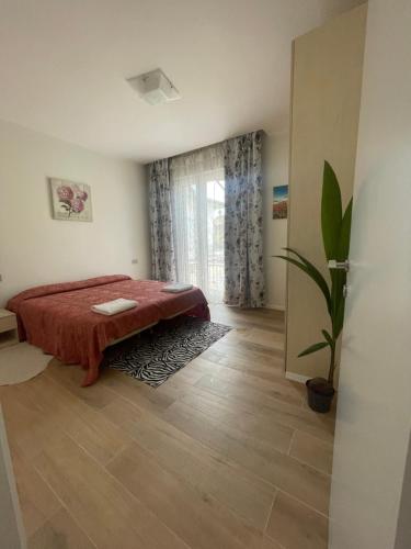 una camera con letto e pianta in vaso di Appartamento Miramare a Rimini