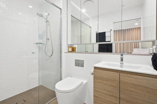 uma casa de banho com um WC, um lavatório e um chuveiro em Signature Residences em Wollongong