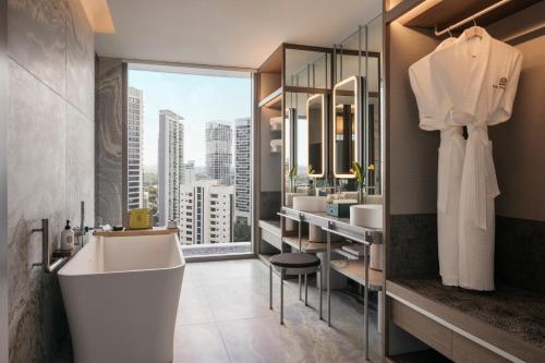 a bathroom with a white tub and a large window at Pan Pacific Orchard in Singapore