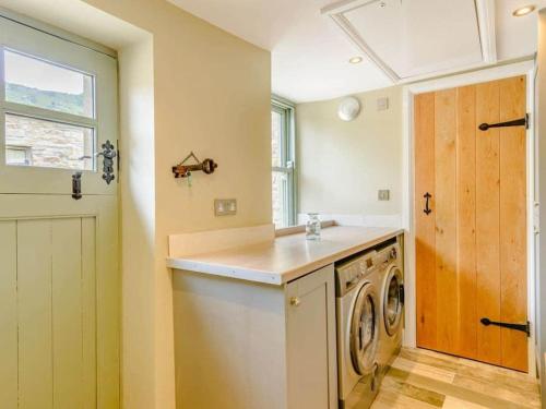 a laundry room with a washing machine and a window at Martin's Farm House in Richmond