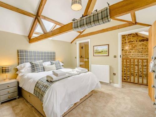 a bedroom with a large bed and wooden ceilings at Martin's Farm House in Richmond