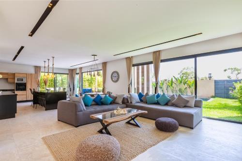 Villa Nounja Golf Amelkis Marrakech في مراكش: غرفة معيشة مع أريكة وطاولة