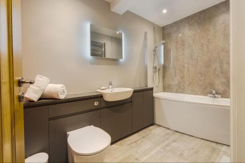 a bathroom with a sink and a toilet and a tub at Joe's Cottage - Brigsteer Village near Kendal in Brigsteer