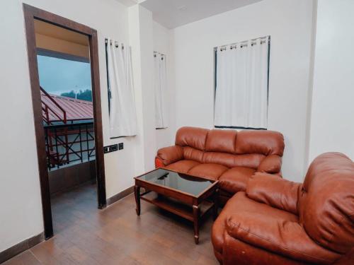 a living room with a leather couch and a table at Aparupa Ambience in Port Blair