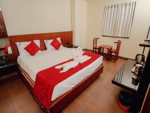 a bedroom with a large bed with a red blanket at Aparupa Ambience in Port Blair