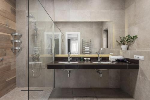 ein Bad mit 2 Waschbecken und einer Dusche in der Unterkunft Frapolli 21 Hotel in Odessa