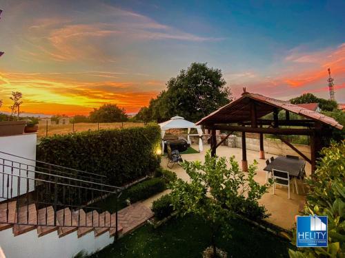 una puesta de sol sobre un patio trasero con cenador en * [Stalettì] *La casa sul mare*, en Stalettì