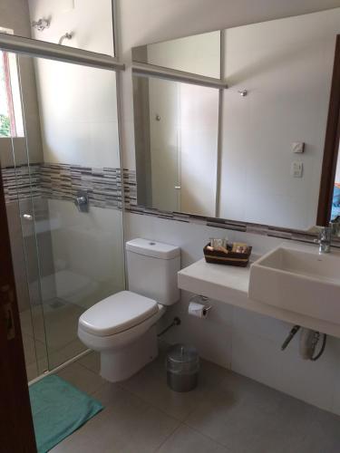 a bathroom with a toilet and a sink and a shower at Bèlla Chacara Morretes - Pr in Morretes