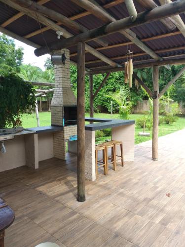 an outdoor entertaining area with a table and a fireplace at Bèlla Chacara Morretes - Pr in Morretes