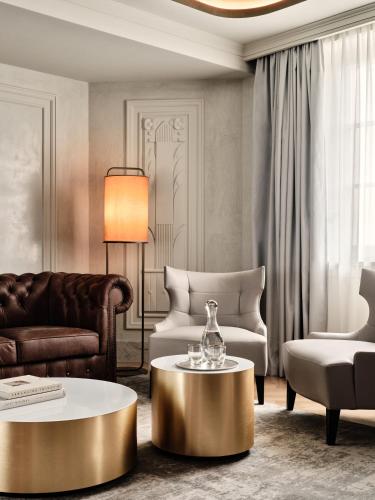 a living room with a gold coffee table and chairs at The Crown Krakow Center - Handwritten Collection ACCOR in Kraków