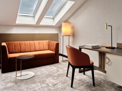a living room with a couch and a table at The Crown Krakow Center - Handwritten Collection ACCOR in Kraków