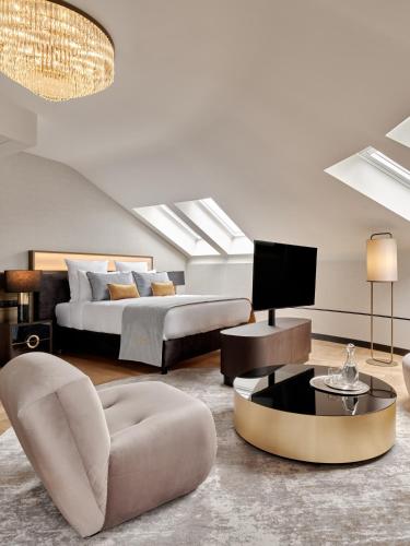 a bedroom with a bed and a living room at The Crown Krakow Center - Handwritten Collection ACCOR in Kraków