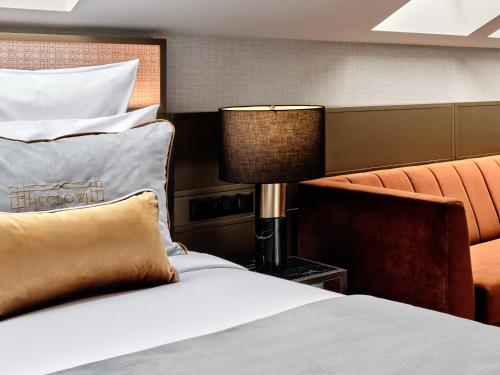 a hotel room with a bed and a lamp at The Crown Krakow Center - Handwritten Collection ACCOR in Kraków