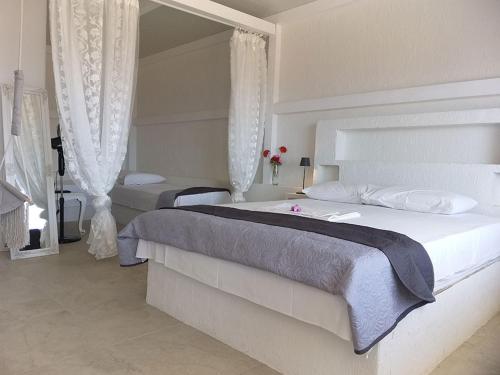 a bedroom with two beds and a mirror at Anatoli Studios in Skhoinoussa