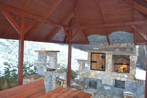 a stone fireplace in a wooden pavilion with a snow at BieszczadzkaDolina in Zagórz