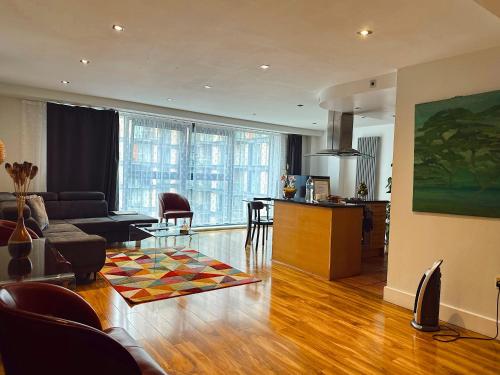 a living room with a couch and a kitchen at Canary Wharf - Luxury Apartments in London
