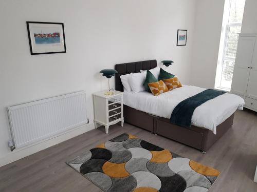 a bedroom with a large bed and a rug at Kingdom apartments in Wolverhampton