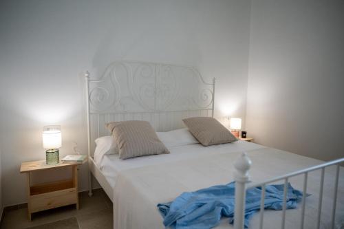 una camera con un letto bianco con due cuscini di Il casalicchio for families a Montalbano