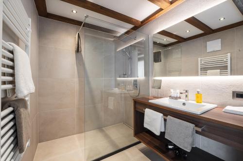 a bathroom with a sink and a shower at Arya Alpine Lodge in Selva di Val Gardena