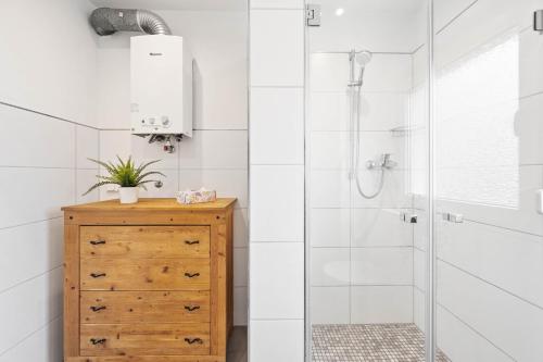 y baño con ducha y tocador de madera. en Casa Aguila - Ruhige, zentrale 4 Zimmerwohnung in Viernheim en Viernheim