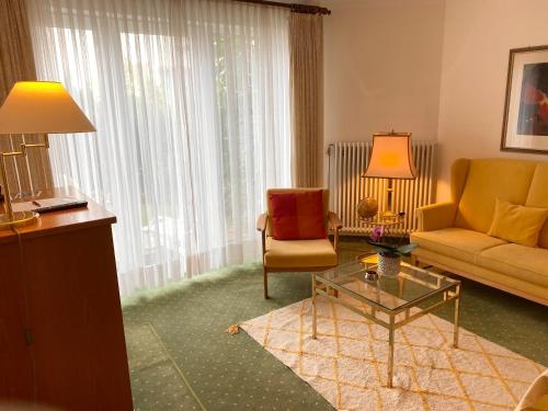 a living room with a couch and a chair and a table at Appartements Gloeser in Badenweiler