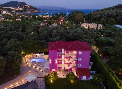 a pink house with lights on the side of it at Ideal Boutique Hotel in Parga