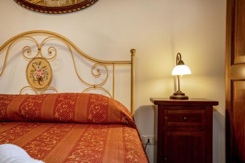 a bedroom with a bed and a lamp on a dresser at Arcaloro Resort in SantʼAngelo di Brolo