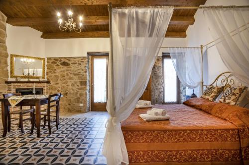 1 dormitorio con 1 cama y 1 mesa en una habitación en Arcaloro Resort, en SantʼAngelo di Brolo