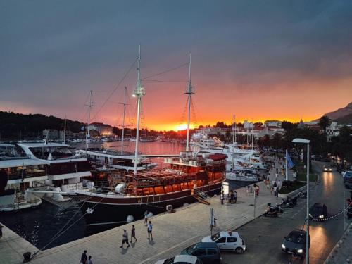 a group of boats docked at a marina at sunset at PORT on riva with parking and sea view in Makarska