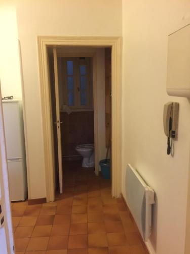 une salle de bain avec toilettes et un téléphone mural dans l'établissement Sympa au calme sur le jardin, à Carcassonne