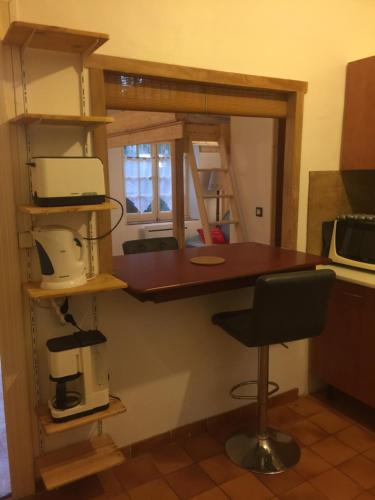 - une cuisine avec un comptoir et une chaise dans une pièce dans l'établissement Sympa au calme sur le jardin, à Carcassonne