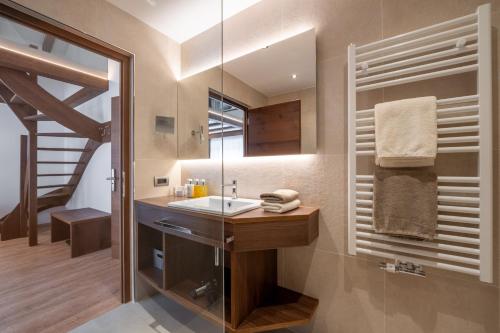 a bathroom with a sink and a staircase at Arya Alpine Lodge in Selva di Val Gardena