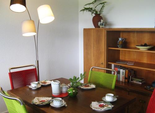 a dining room table with four chairs and a table with food on it at Ferienwohnung Schwarzwald Oase Kniebis in Kniebis