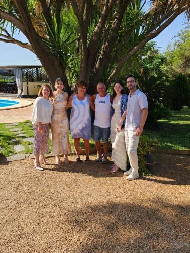 a group of people posing for a picture in front of a tree at Finca la Yuca in Ontinyent