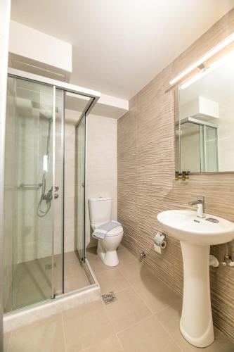 a bathroom with a toilet and a sink and a shower at Esperia apartments in Platanes