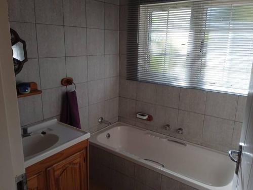 un baño con bañera y lavabo en Mphesheleng Guesthouse, en Bela-Bela