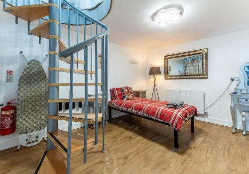 a room with a bed and a spiral staircase at UPSIDE DOWN HOUSE Sleeps up to 6 Guests and is Near Sherwood Forest At Fairview Farm in NOTTINGHAM set in 88 acres in Nottingham