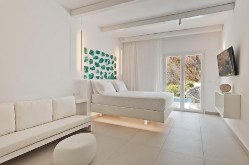 a white living room with a bed and a couch at Enilion Luxury Suites in Karpathos