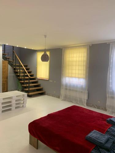 ein Schlafzimmer mit einem roten Bett und einer Treppe in der Unterkunft Libau Apartment in Liepāja