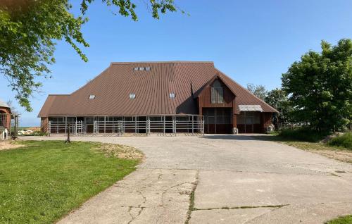 a large brown barn with a gambrel roof at Tetenshof für Pferdeliebhaber in Westerhever