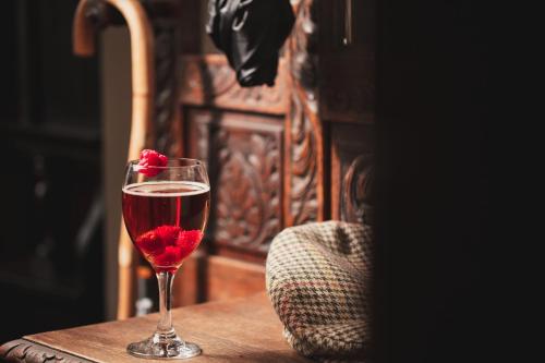 a glass of red wine sitting on a table at Tulloch Castle Hotel ‘A Bespoke Hotel’ in Dingwall