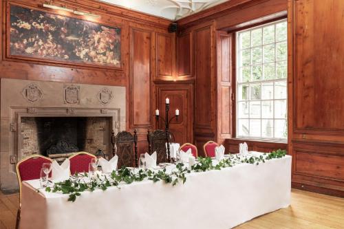 a large room with a table with flowers on it at Tulloch Castle Hotel ‘A Bespoke Hotel’ in Dingwall