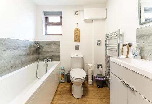 a bathroom with a toilet and a tub and a sink at UPSIDE DOWN HOUSE Sleeps up to 6 Guests and is Near Sherwood Forest At Fairview Farm in NOTTINGHAM set in 88 acres in Nottingham