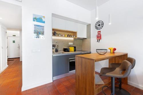 a kitchen with a wooden table and a counter at Estoril Art and Surf in Estoril