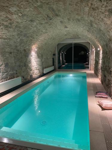 une piscine dans un tunnel en pierre avec une piscine dans l'établissement Appartement avec accès piscine et jardin dans hôtel particulier, à Nérac