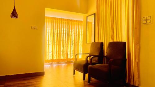 a living room with two chairs and a window at JACK'S DEN residency in Puducherry