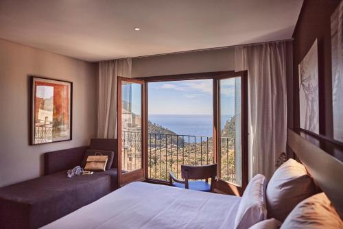 a hotel room with a bed and a large window at Maristel Hotel & Spa in Estellencs