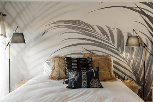 a bedroom with a bed with black and white pillows at Voelkliplaan 8 in Jongensfontein