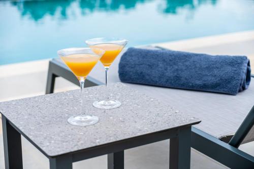 two glasses of orange juice sitting on a table at Vathy Villas in Preveza